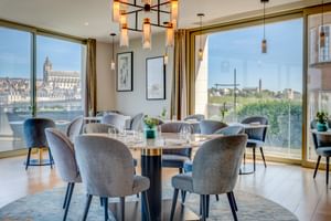Modern restaurant with velvet chairs, round tables, and floor-to-ceiling windows overlooking Blois cathedral and the Loire River.