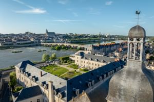 Aerial view of Hotel Fleur de Loire Blois with historic tower, overlooking Loire River and stone bridge connecting to Blois old town.