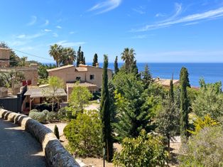 Blick über landestypische mallorquinische Häuser und Gärten zum Meer
