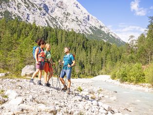 Hikers by the mountain river in Leutasch on the hike from Füssen to Meran