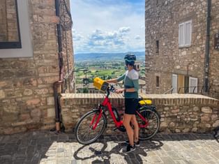 Radfahrerin blickt von Assissi in die Ferne