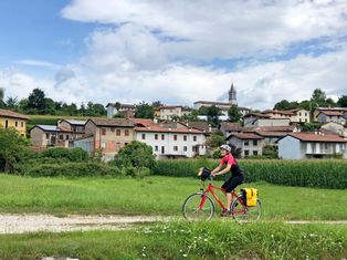 Radfahrerin auf Friaul-Rundfahrt in der Nähe eines Dorf