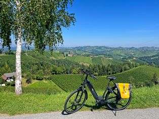 Panoramic view over the vineyards of Gamlitz, with e-bike in the foreground