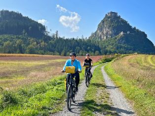 Two cyclists on a gravel path with Hochosterwitz Castle in the background