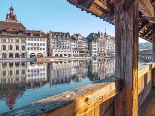 Blick über die hölzerne überdachte Kappelbruecke auf die Altstadt von Luzern