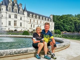 A pair of cyclists in front of Chenonceau Castle