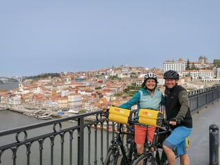 Glückliches Radfahrerpärchen auf der Brücke in Porto