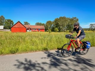 Radfahrer auf dem Kattegattleden bei Hjortsberg – mit typischem rotem Schwedenhaus im Hintergrund