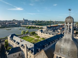 Aerial view of Hotel Fleur de Loire Blois with historic tower, overlooking Loire River and stone bridge connecting to Blois old town.