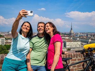 Zwei Frauen und ein Mann machen Selfie in Turin