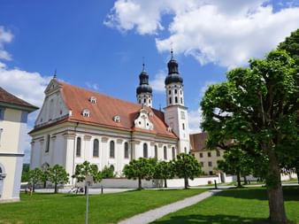 Stiftskirche mit Wiese und Bäumen in Obermarchtal