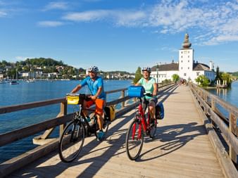 Cyclists in front of Castle Orth in Salzkammergut