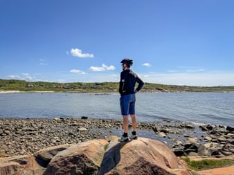 Radfahrer auf Felsen in Stora Skär blickt in die Ferne