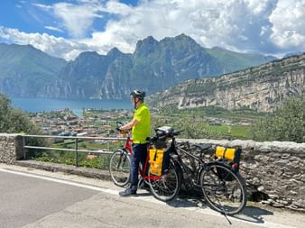 Cyclists at a viewpoint in Nago overlooking Lake Garda.