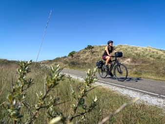 Radfahrerin in Dünenlandschaft