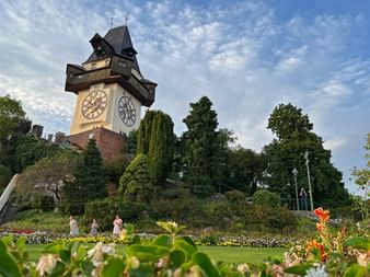Clock tower in Graz with garden in the foreground