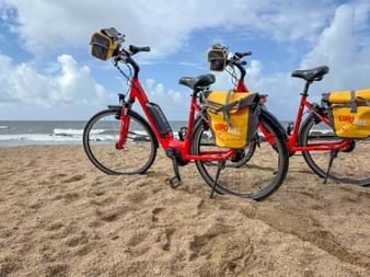 Two red Eurobike rental bikes on the beach