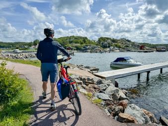 Radfahrer schiebt Leihrad am Hafen in Särö