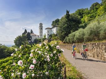 Two cyclists in front of the Castello di Cormons in Monte Quarin
