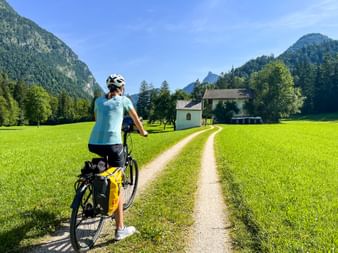 Cyclist on the cycle path in front of a chapel in Unken.