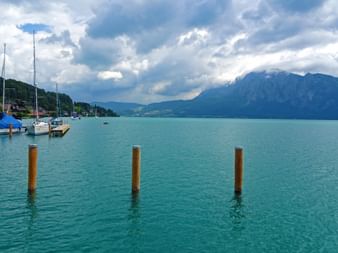 Boote am türkis-blauen See mit Berge im Hintergrund