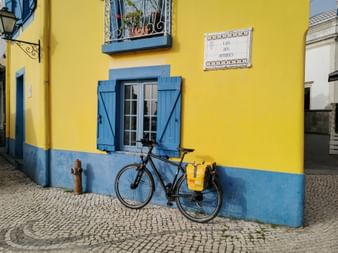 Eurobike rental bike Plus in front of a yellow and blue building façade in Aveiro