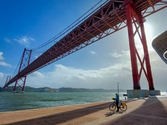 Cyclist under a bridge in Lisbon