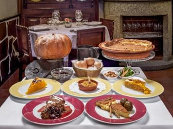 Traditionelle portugiesische Desserts auf bunten Tellern im Restaurante Fialho in Évora, Alentejo, mit verschiedenen Kuchen und Süßspeisen.