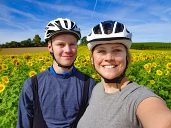 Christine and her brother in front of a sunflower field