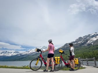 At Lake Sils, two cyclists gaze into the distance