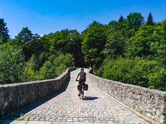 Radfahrer auf einer Steinbrücke