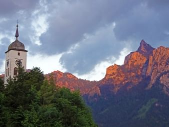 St John's Chapel Traunkirchen in front of a mountain at sunset