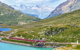 Eisenbahn am See mit türkisem Wasser und Bergpanorama