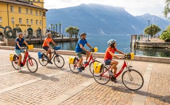 Radfahrer in Riva mit Blick auf den Gardasee