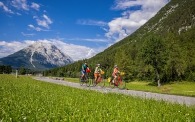 Radfahrer auf Radweg mit Gebirge im Hintergrund