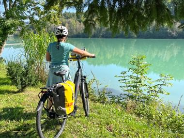 Cyclist standing by the river