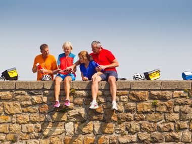 Cyclists make a break sitting on a bridge