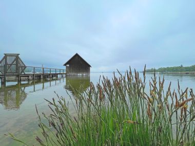 Ammersee with jetty and reed grass in the foreground