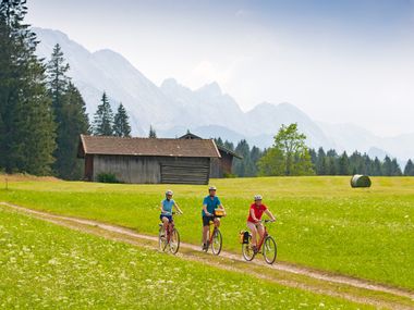 Radfahrer auf grüner Wiese im Werdenfelser Land