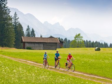 Cyclists on a green meadow in Werdenfelser Land