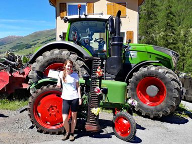 Cyclist in front of vintage tractor in Schanf