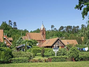 Blick auf die Kirche von Nida, umgeben von landestypischen Holzhäusern