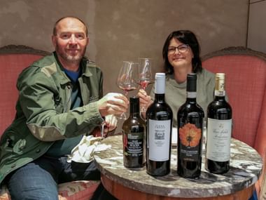 Aktivurlauber stoßen mit Weingläser bei Weinverkostung in Montepulciano an