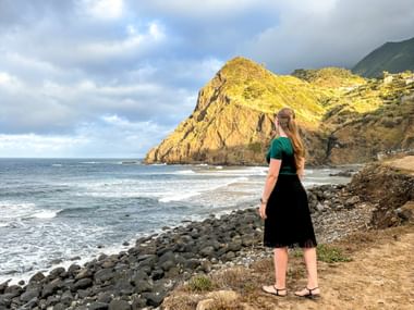 Holidaymaker in Porto da Cruz with a view of the sunlit coastline