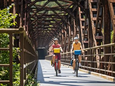 Two cyclists on the Ponte di Ferro in the Canal Valley