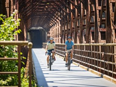 Zwei Radfahrer auf einer Brücke im Kanaltal