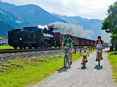 Radfahrer neben einer Dampflok