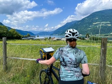 Radfahrerin blickt auf Ossiacher See