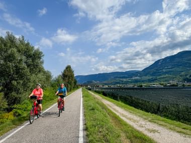 Two holidaymakers cycle along the Adige cycle path