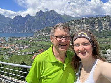 Father and daughter take a selfie on a viewing terrace near Nago overlooking Lake Garda.